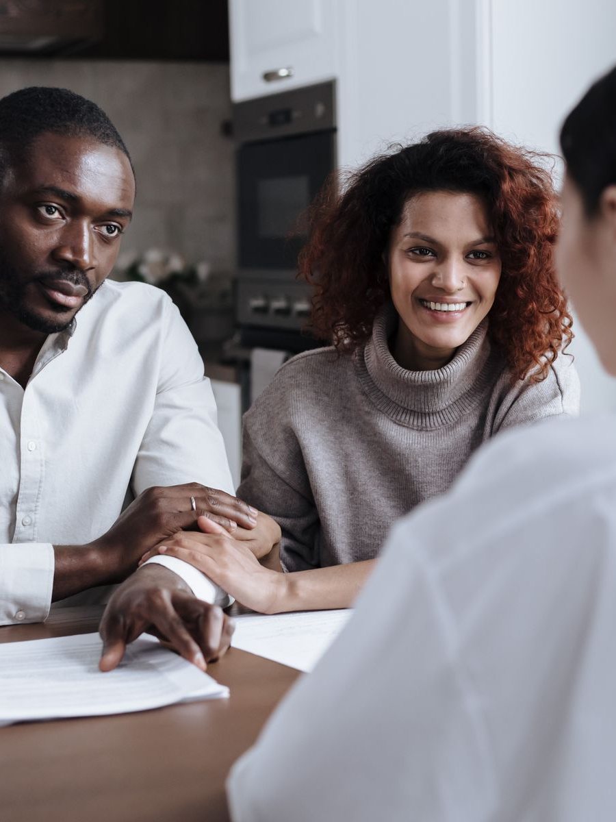 A couple smile as an adviser explains their cover